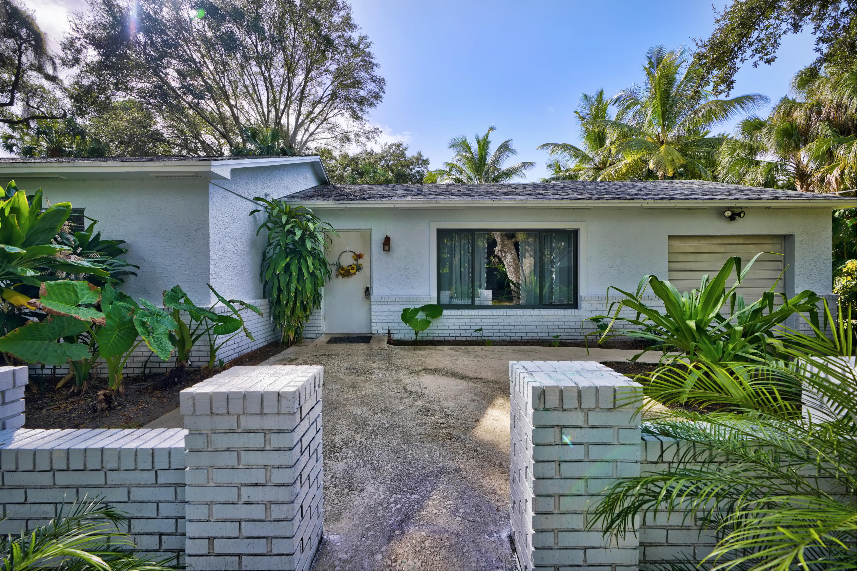 a front view of a house with a yard and potted plants