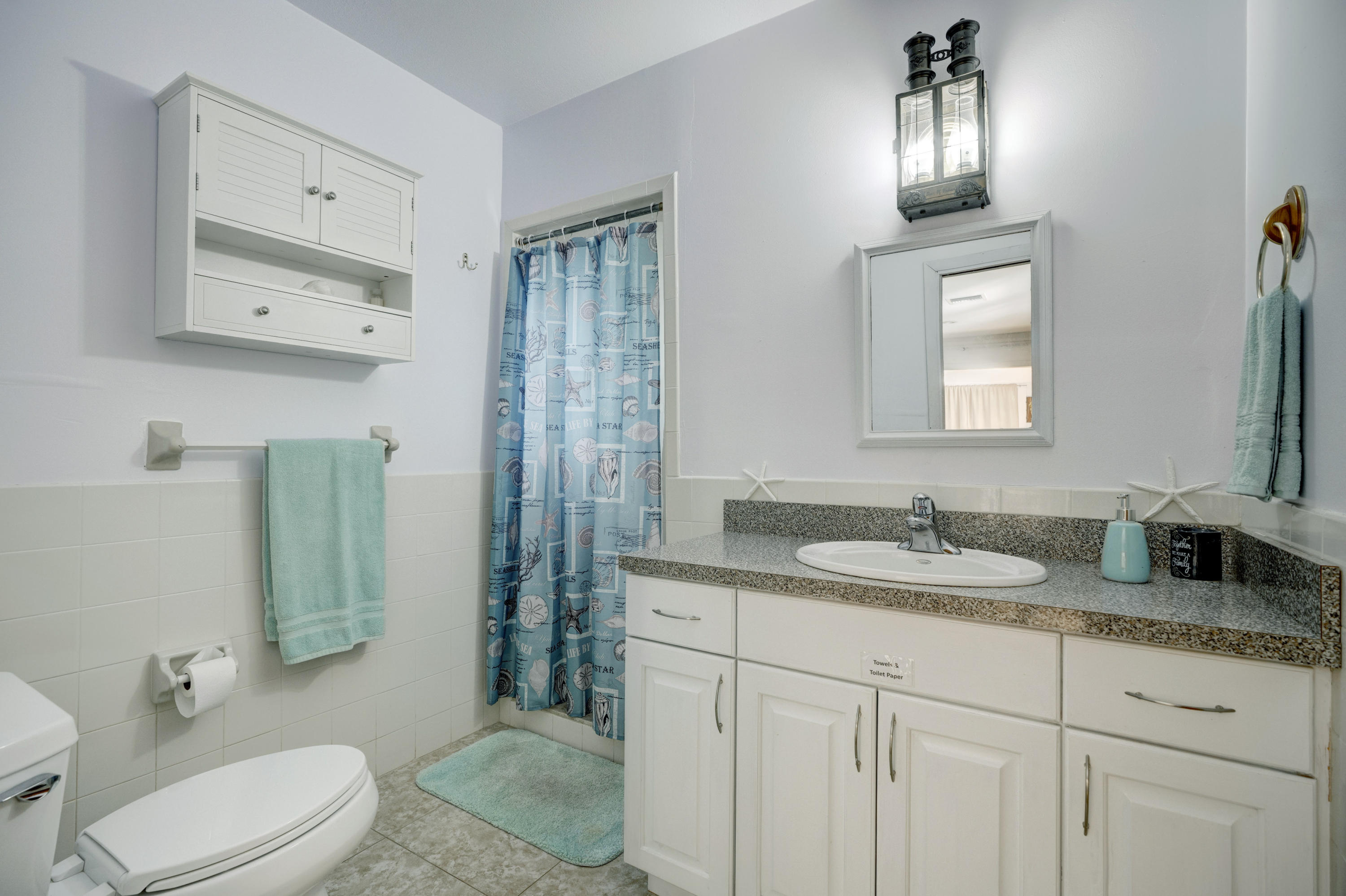 11061 Ellison Wilson Road North Palm Beach, FL 33408 - Photo 8 of 41 a bathroom with a granite countertop toilet sink and mirror