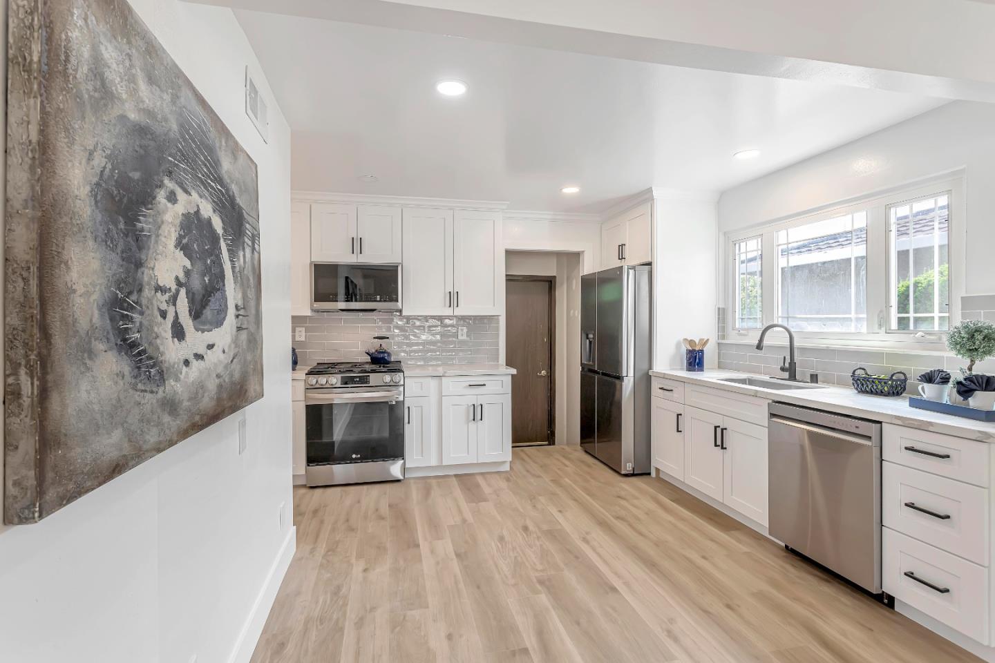 1548 Spring Street Mountain View, CA 94043 - Photo 14 of 40 a kitchen with stainless steel appliances a stove a sink dishwasher a refrigerator and a oven with wooden floor