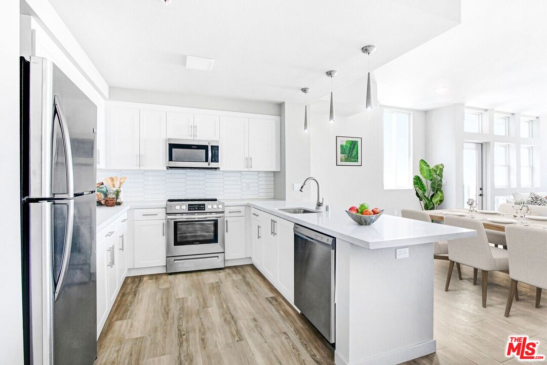 2847 Leeward Avenue, Unit 607 Los Angeles, CA 90005 - Photo 7 of 14 a kitchen with a stove a sink and a refrigerator