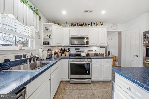 a kitchen with stainless steel appliances granite countertop a sink dishwasher stove and refrigerator