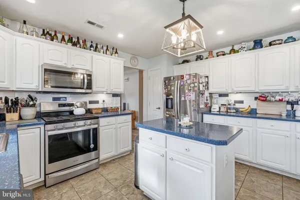 a kitchen with stainless steel appliances granite countertop a stove sink microwave and cabinets