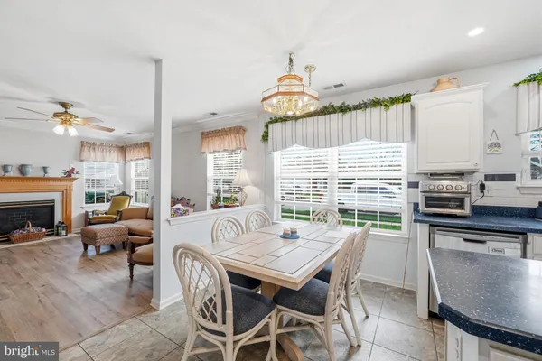 a dining room with furniture a chandelier and wooden floor