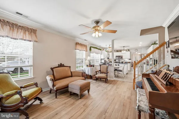 a living room with furniture a ceiling fan and a window
