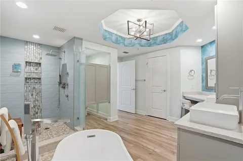 a bedroom with a bed a chandelier and a window