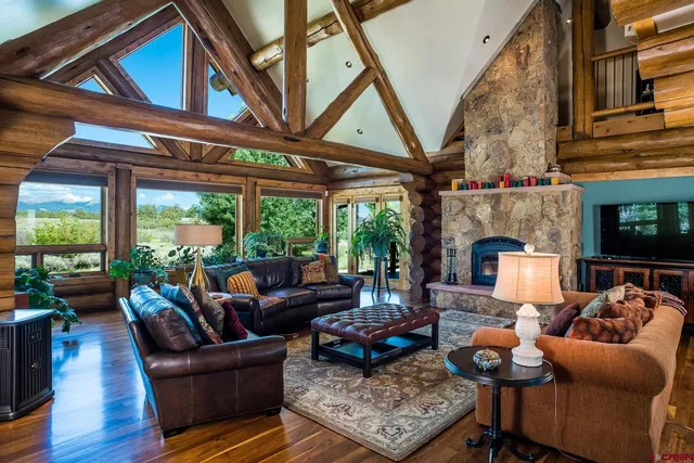 a living room with furniture a fireplace and a large window