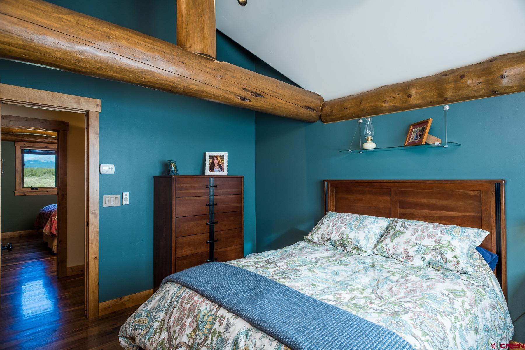 15255 Road 35 Mancos, CO 81328 - Photo 27 of 36 a bedroom with a bed and wooden floor