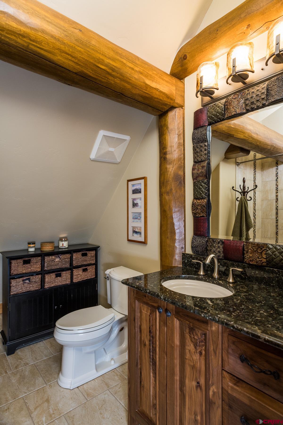 15255 Road 35 Mancos, CO 81328 - Photo 28 of 36 a bathroom with a granite countertop toilet sink and mirror