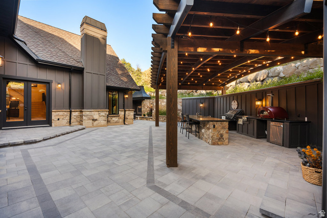 1141 South Oak Leaf Lane Springville, UT 84663 - Photo 118 of 147 Expansive paver patio with an integrated outdoor kitchen featuring built-in appliances and a stone-clad island