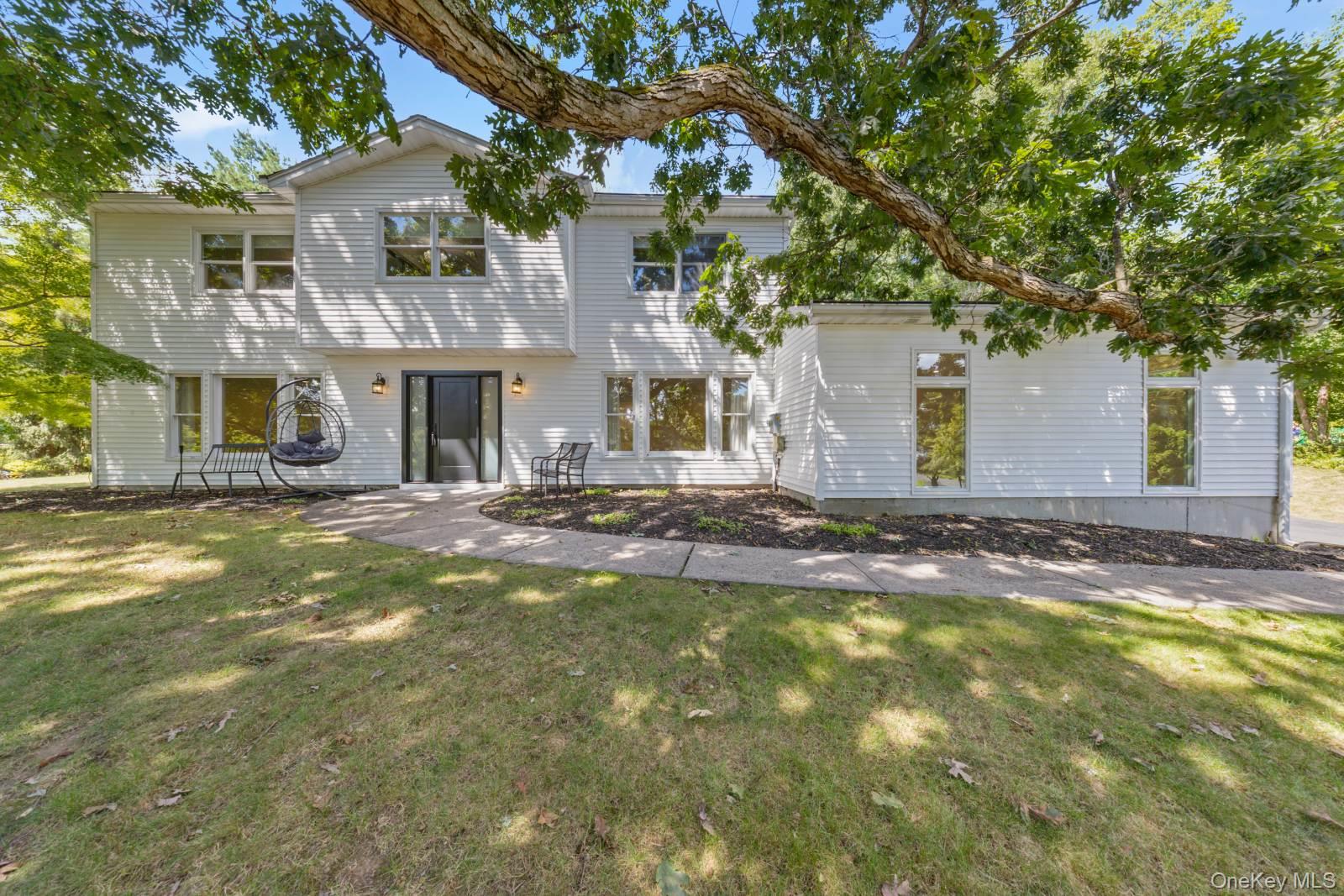 a front view of a house with a yard and trees