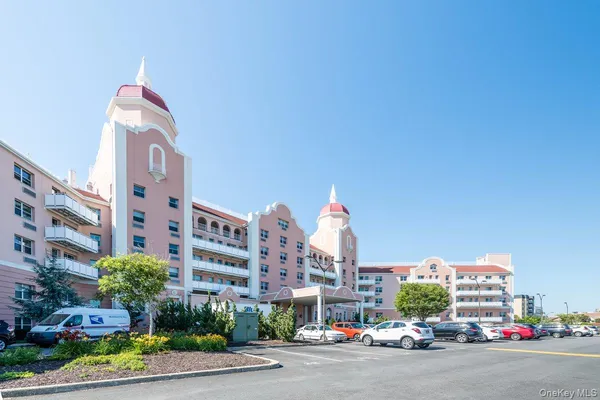 a view of a tall building and a cars parked in front of it