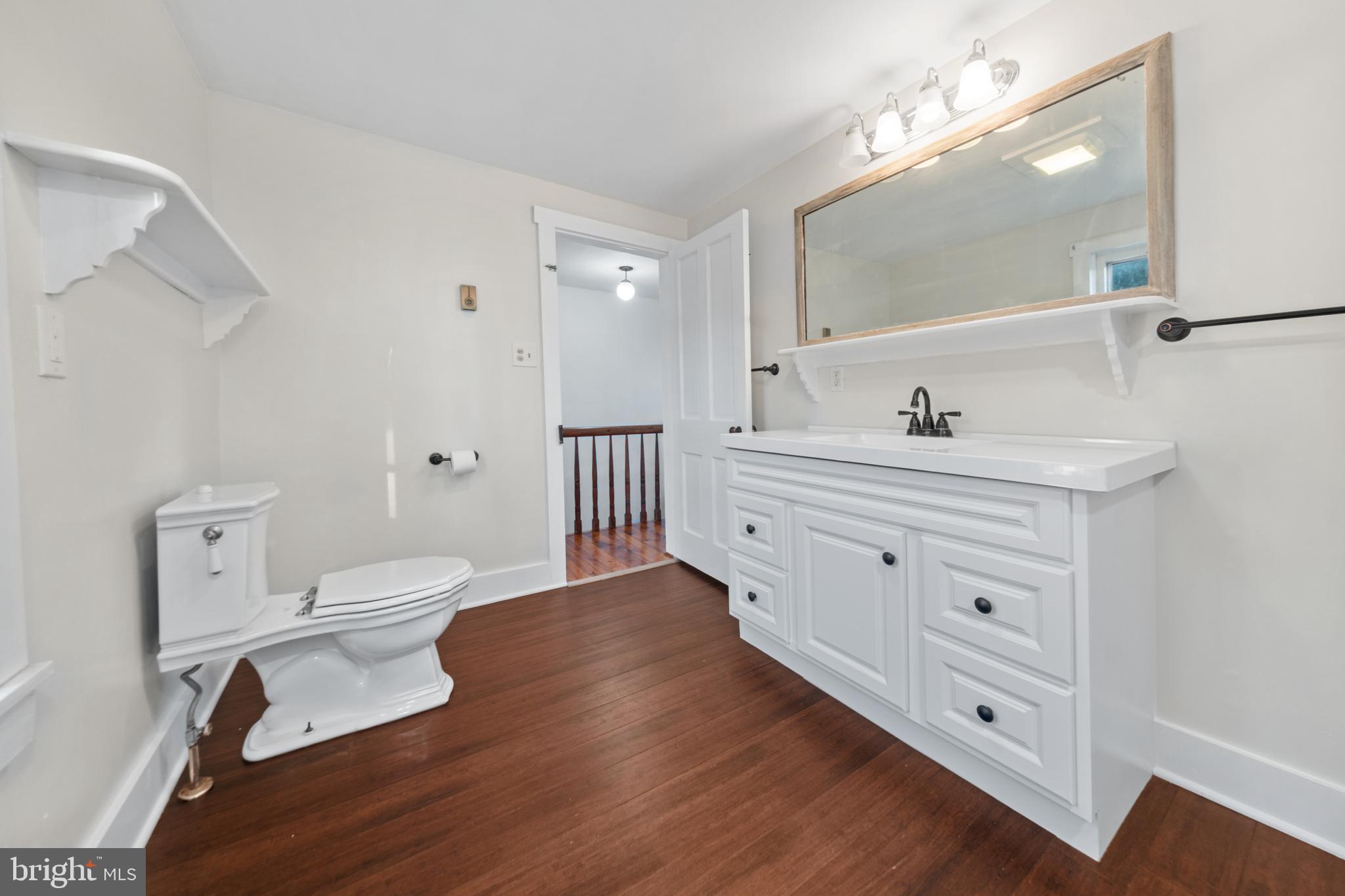 290 Howards Chapel Road Winchester, VA 22603 - Photo 11 of 33 a bathroom with a toilet a sink a mirror and a window