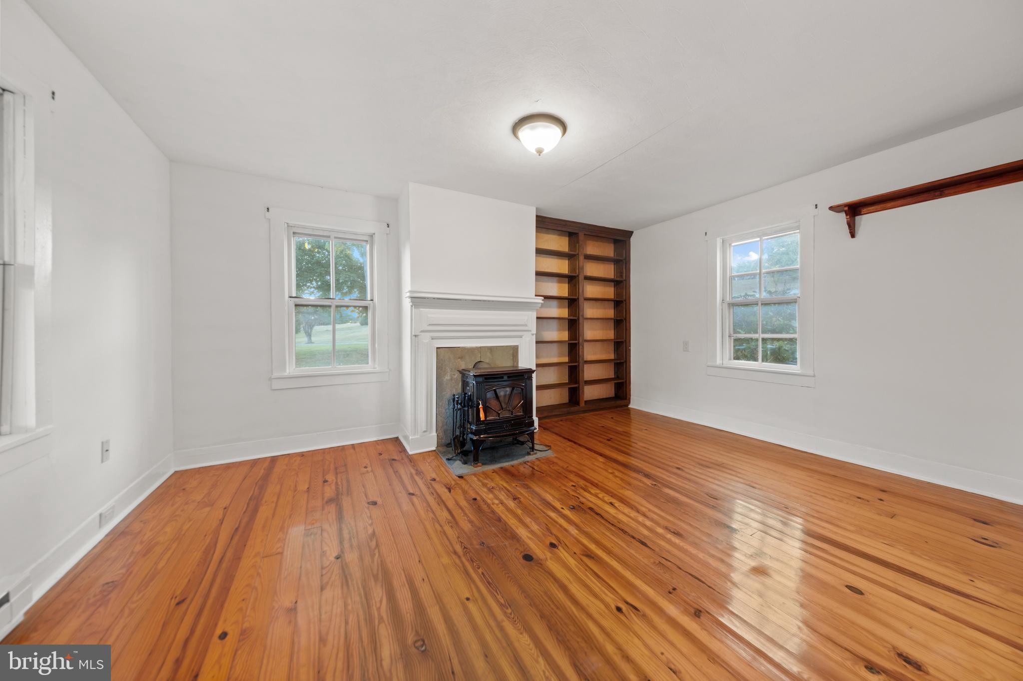 290 Howards Chapel Road Winchester, VA 22603 - Photo 6 of 33 an empty room with windows and a fireplace