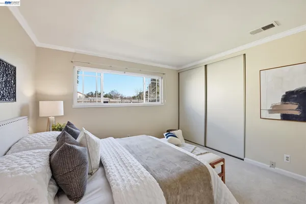 a bedroom with a bed and a painting on the wall