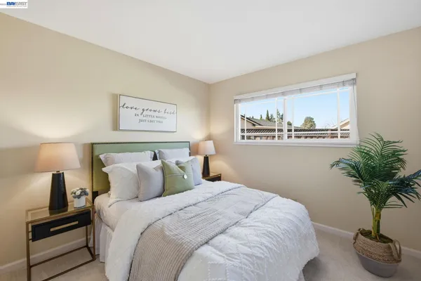 a bedroom with bed and a potted plant