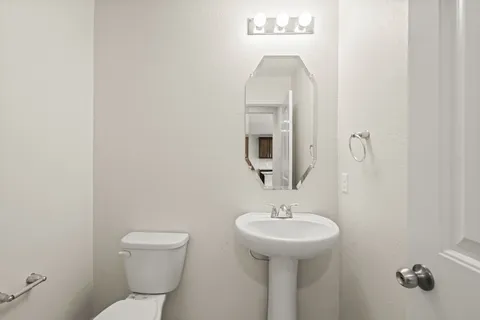 a bathroom with a toilet sink and mirror