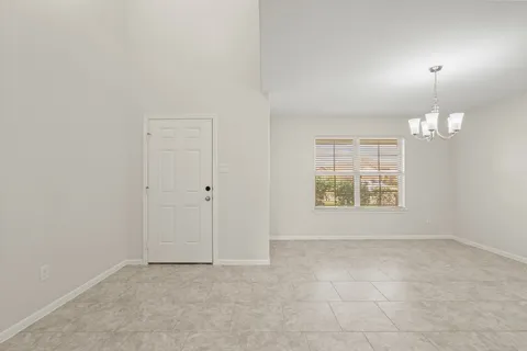 an empty room with chandelier fan