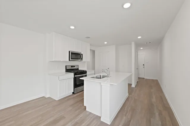 a kitchen with stainless steel appliances granite countertop a sink stove and refrigerator