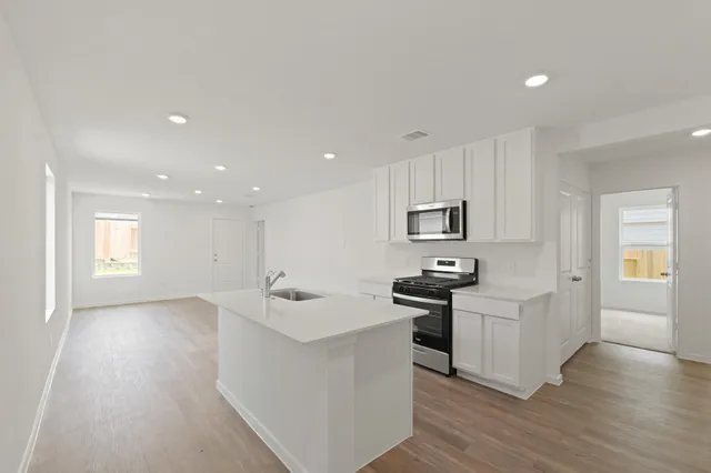a kitchen with stainless steel appliances granite countertop a sink stove and refrigerator