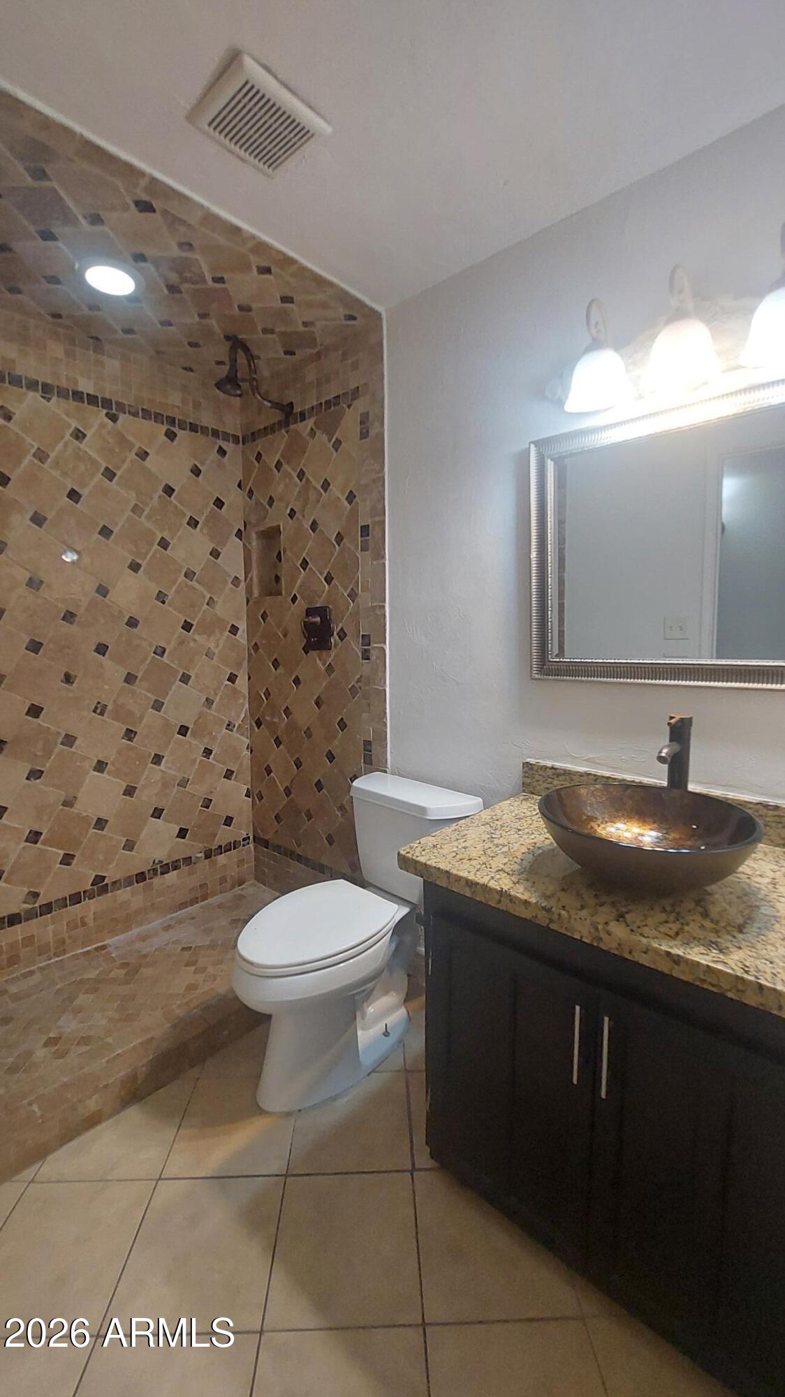 2448 West Freeway Lane Phoenix, AZ 85021 - Photo 15 of 27 a bathroom with a granite countertop toilet a sink and a mirror