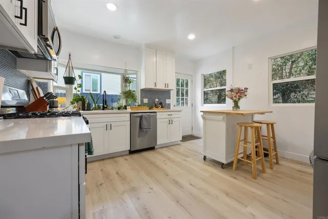 a kitchen with a sink a cabinets and chairs in it