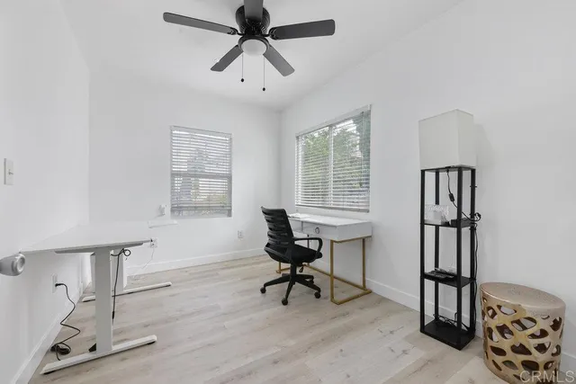 a view of a workspace with furniture and a window