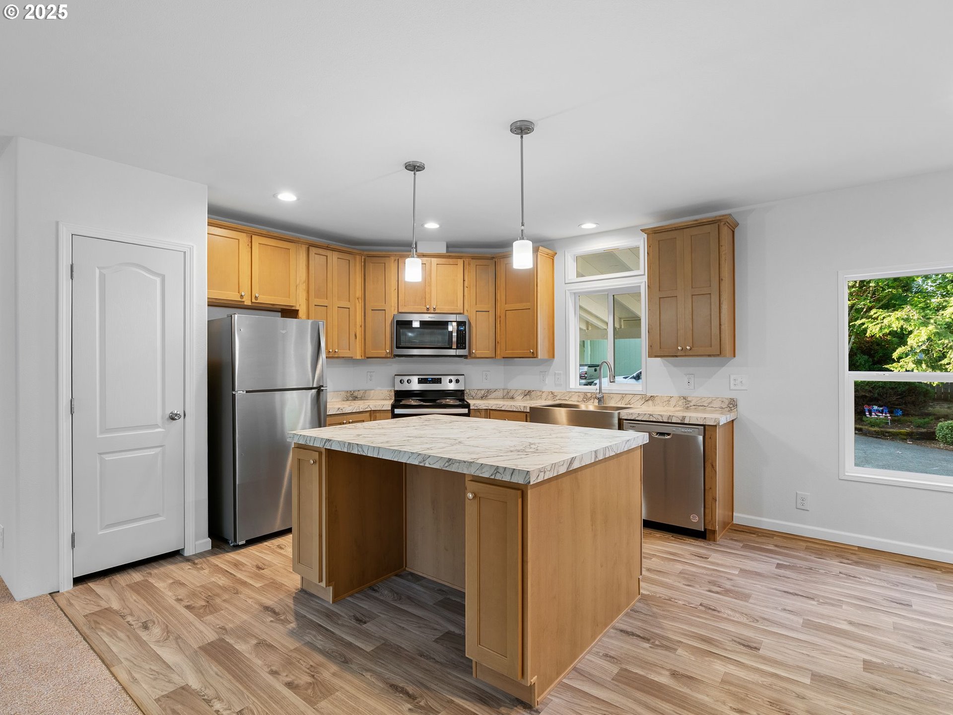 12904 Southeast Ramona Street Portland, OR 97236 - Photo 11 of 35 a kitchen with stainless steel appliances granite countertop a sink a stove a refrigerator and island with wooden floor