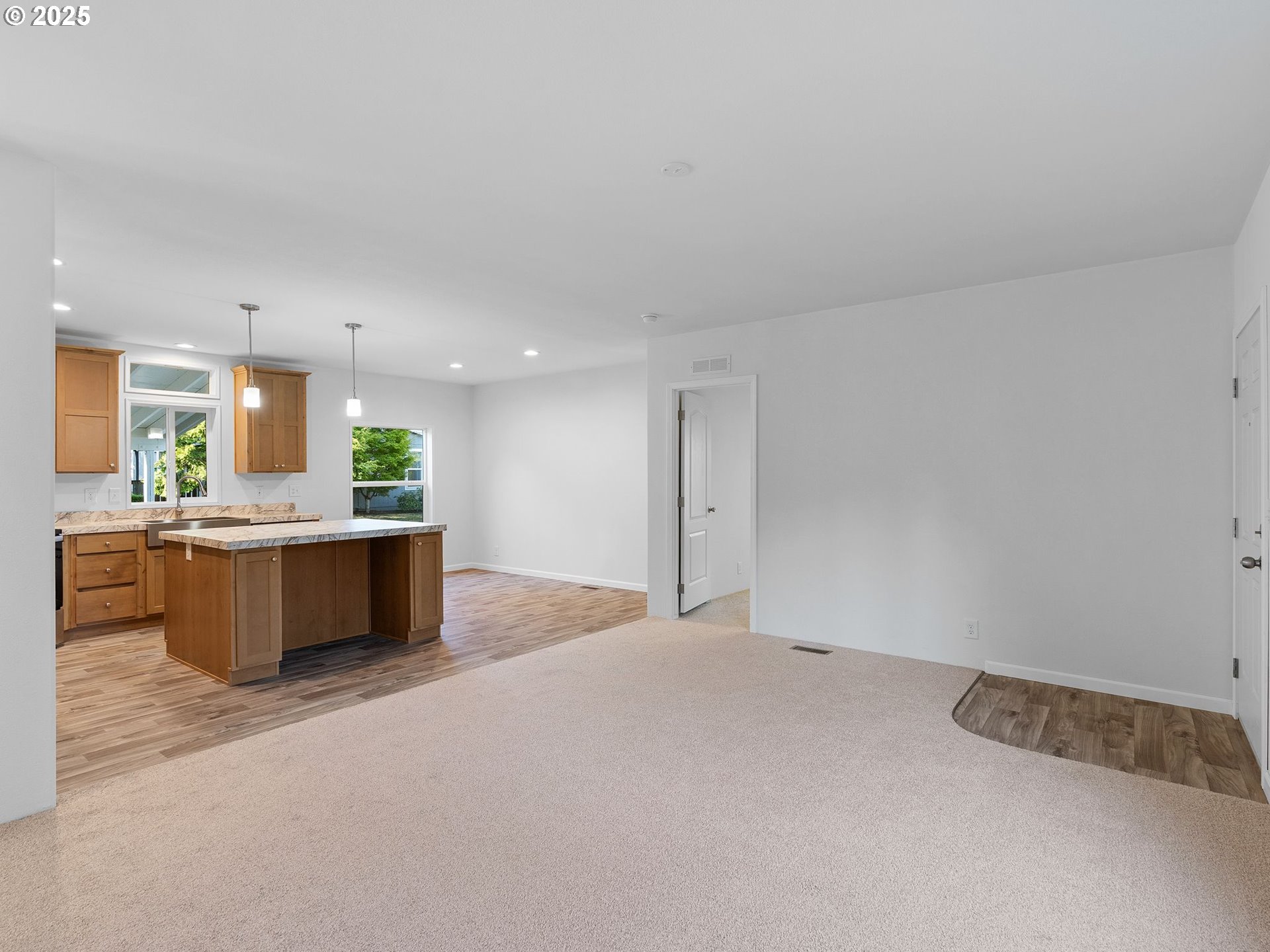 12904 Southeast Ramona Street Portland, OR 97236 - Photo 5 of 35 a large kitchen with kitchen island a sink stainless steel appliances and cabinets
