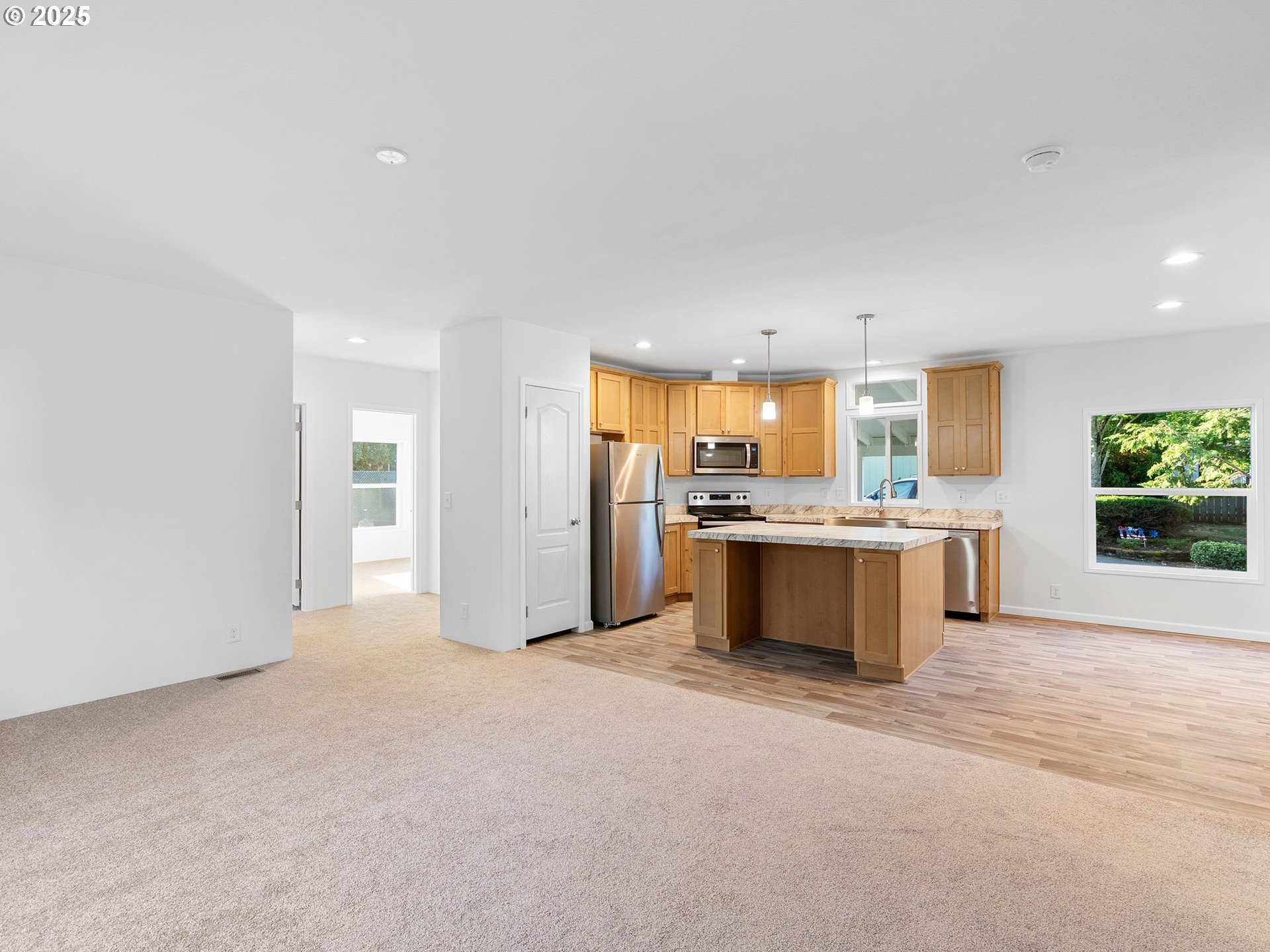 12904 Southeast Ramona Street Portland, OR 97236 - Photo 6 of 35 a large kitchen with a refrigerator and a stove top oven