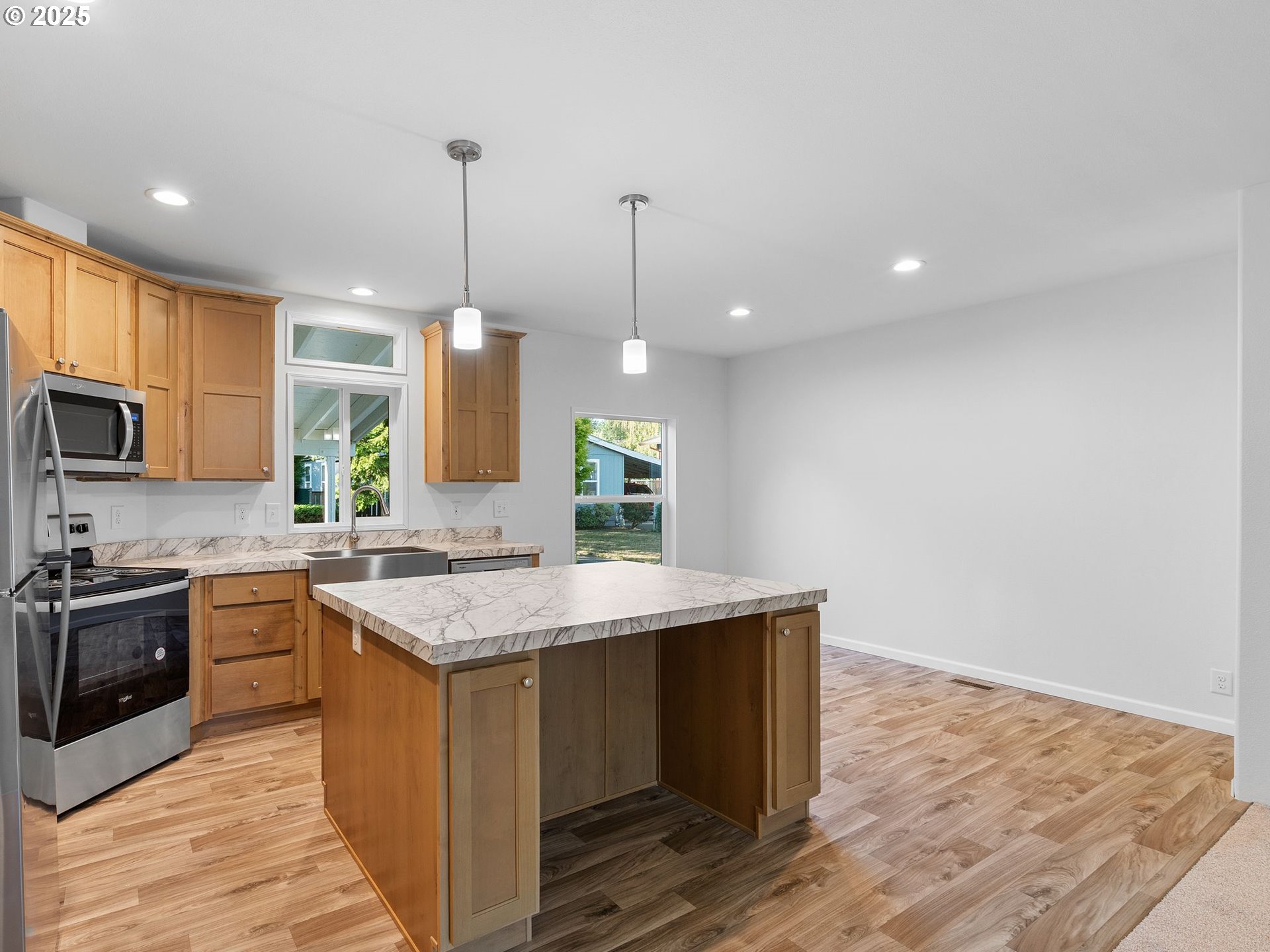 12904 Southeast Ramona Street Portland, OR 97236 - Photo 7 of 35 a kitchen with kitchen island a sink stainless steel appliances and cabinets