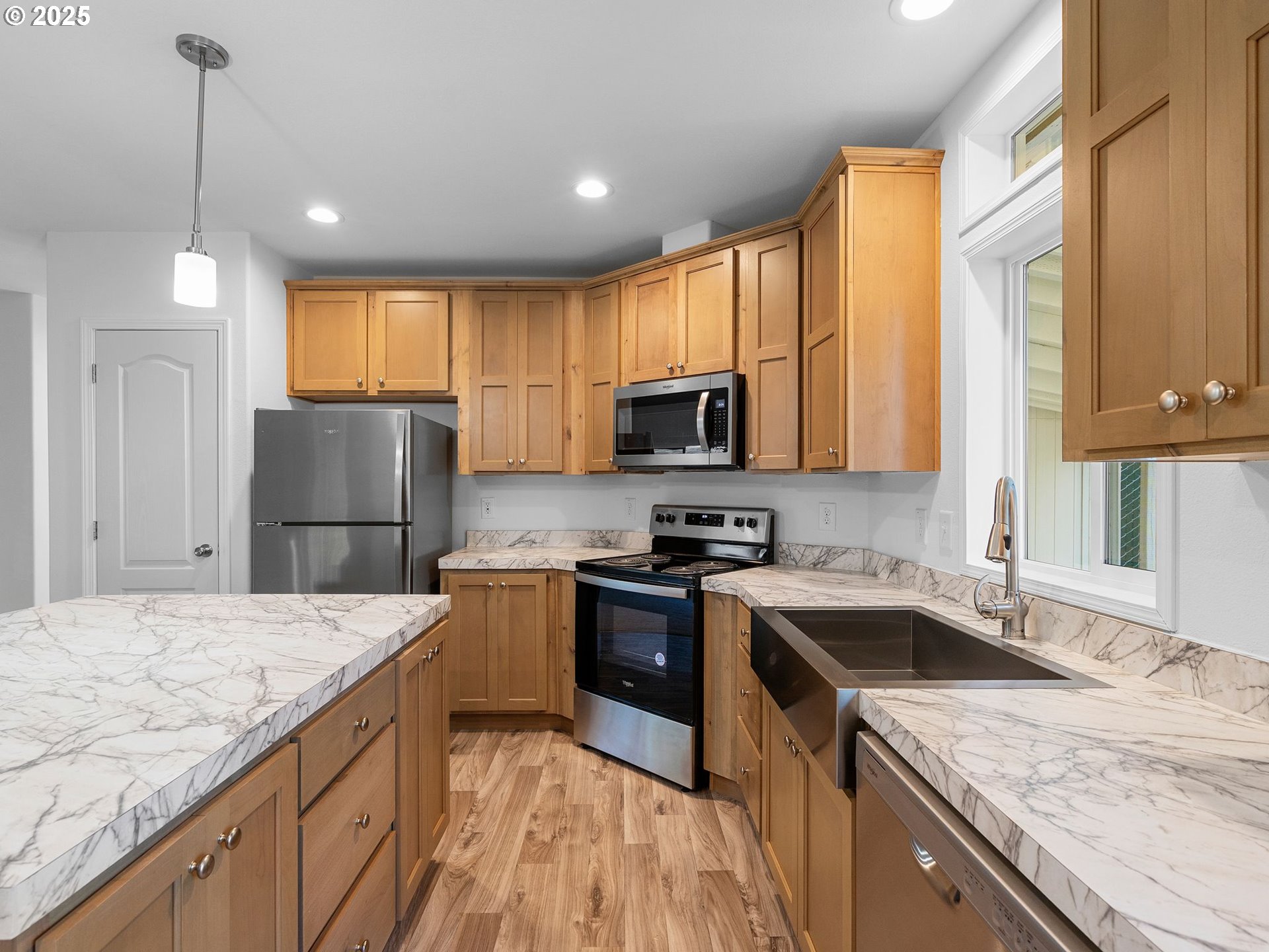 12904 Southeast Ramona Street Portland, OR 97236 - Photo 9 of 35 a kitchen with a sink a stove a microwave and refrigerator