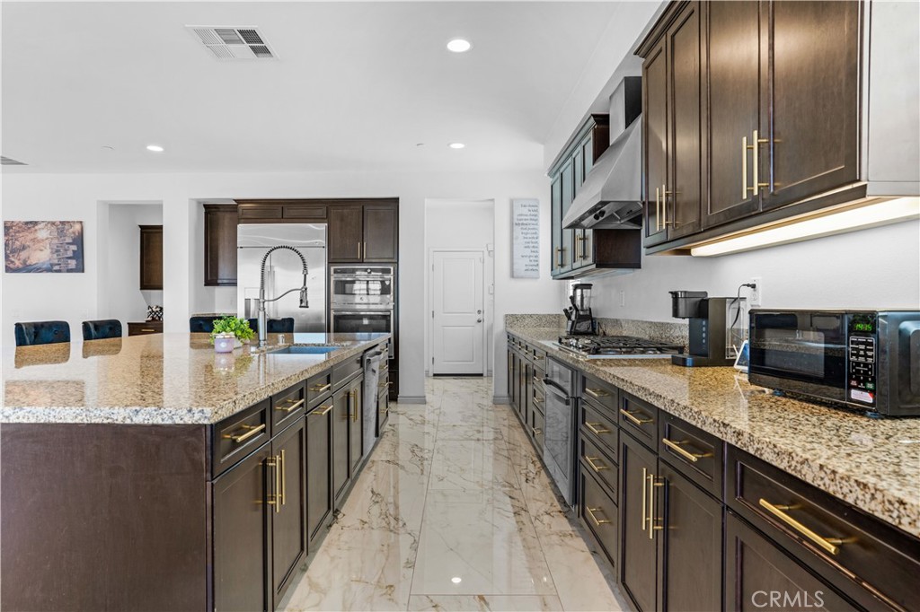 17195 Compass Drive Riverside, CA 92503 - Photo 22 of 75 a kitchen with stainless steel appliances granite countertop a sink a stove and a refrigerator