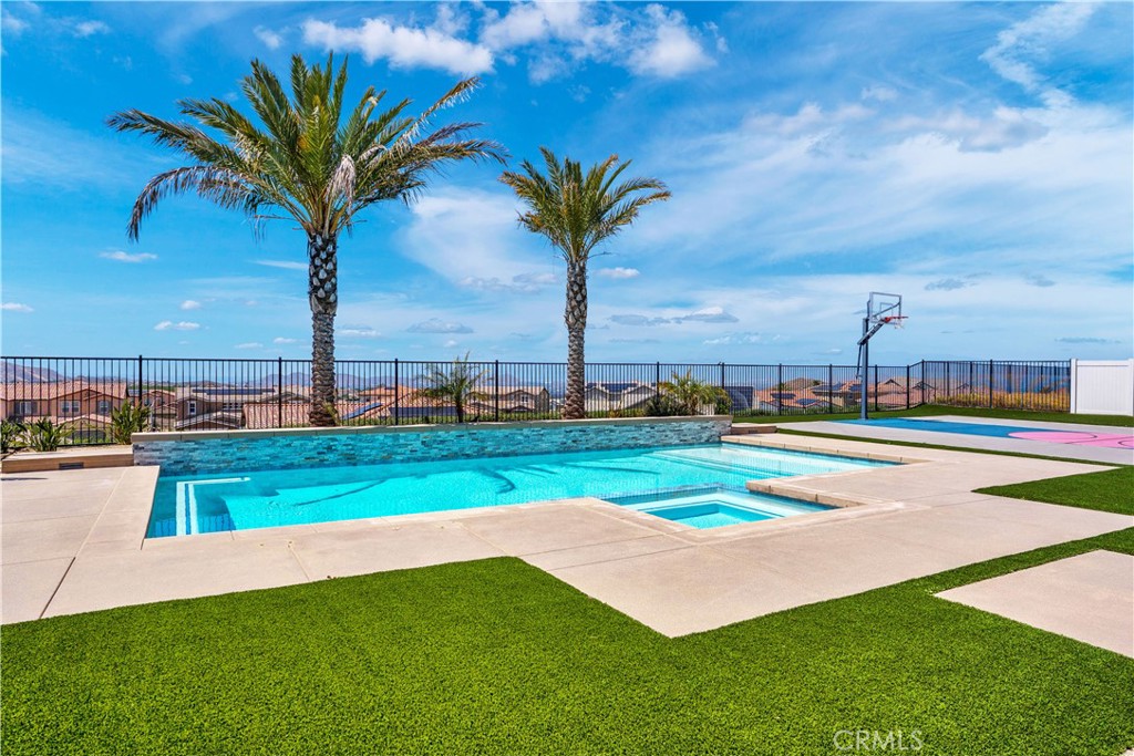 17195 Compass Drive Riverside, CA 92503 - Photo 68 of 75 a view of a swimming pool with a yard and palm trees
