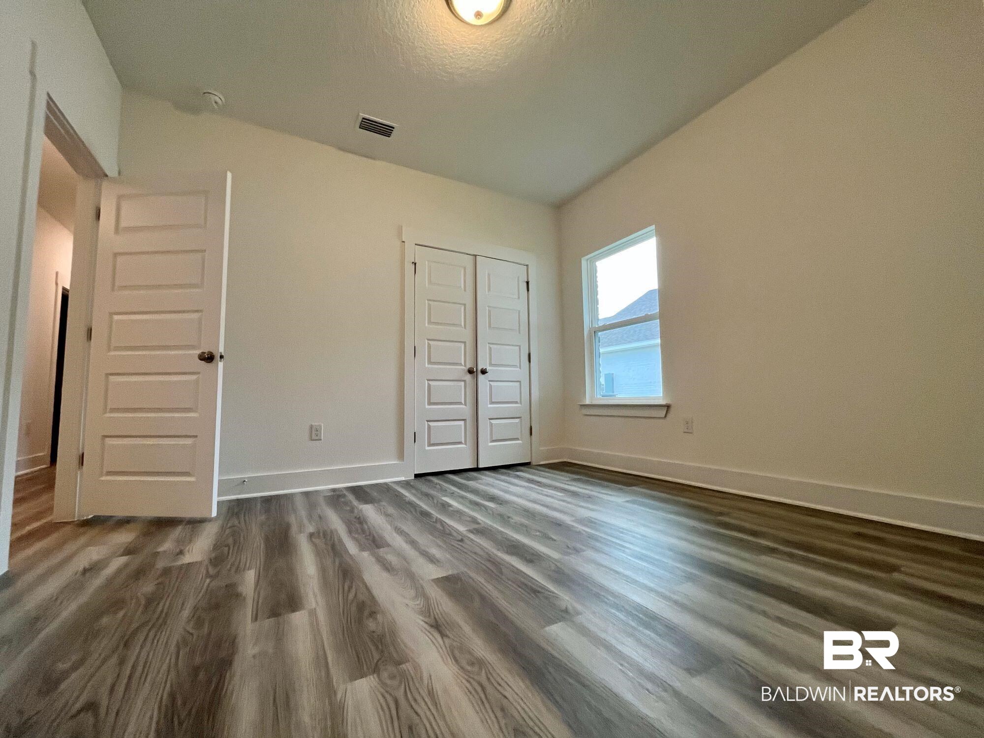 334 Barndling Street Fairhope, AL 36532 - Photo 20 of 34 Unfurnished bedroom with a textured ceiling, lofted ceiling, dark hardwood / wood-style floors, and a closet