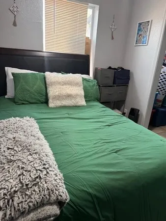 a bedroom with a bed and wooden floor