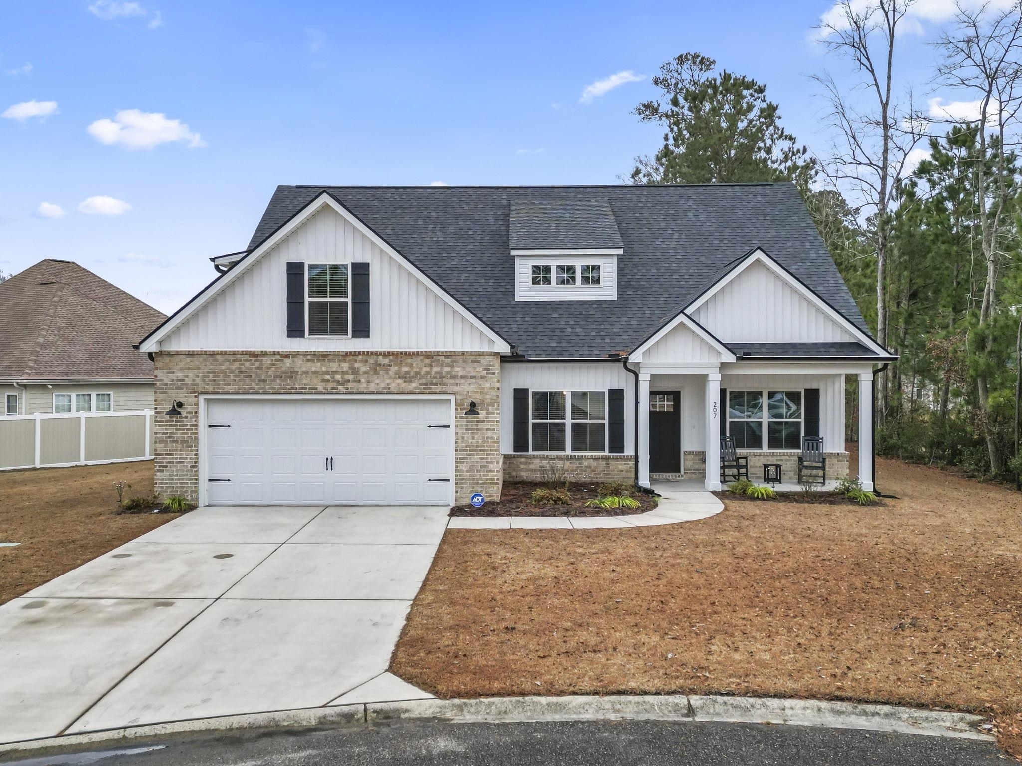 Modern inspired farmhouse featuring roof with shingles, board and batten siding, concrete driveway, and a porch