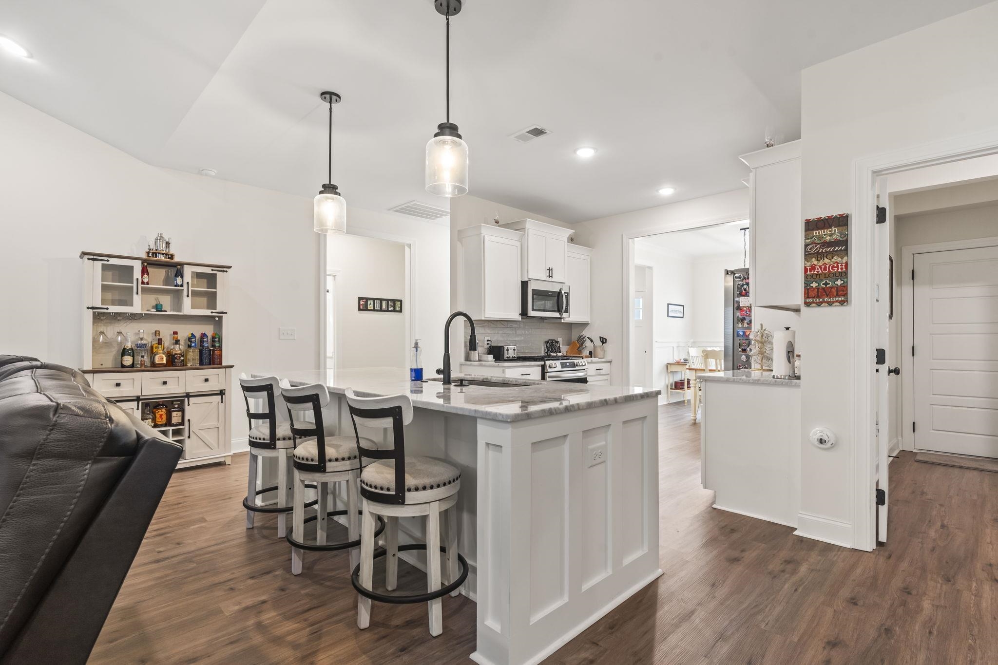 207 Putney Court Conway, SC 29526 - Photo 36 of 38 Kitchen featuring white cabinets, dark wood-style flooring, open floor plan, light stone counters, and recessed lighting