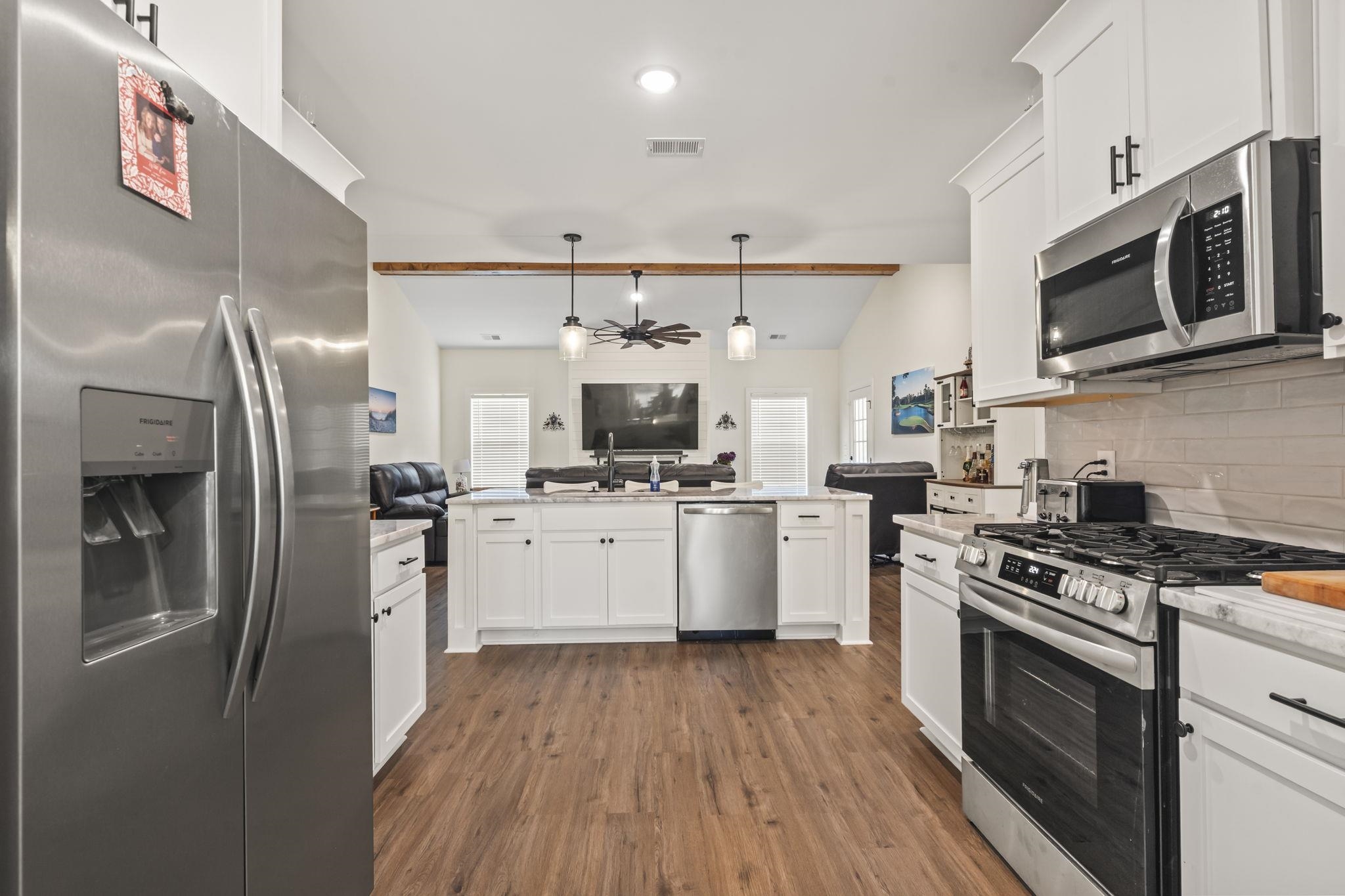 207 Putney Court Conway, SC 29526 - Photo 35 of 38 Kitchen with open floor plan, stainless steel appliances, decorative light fixtures, white cabinets, and dark wood-type flooring