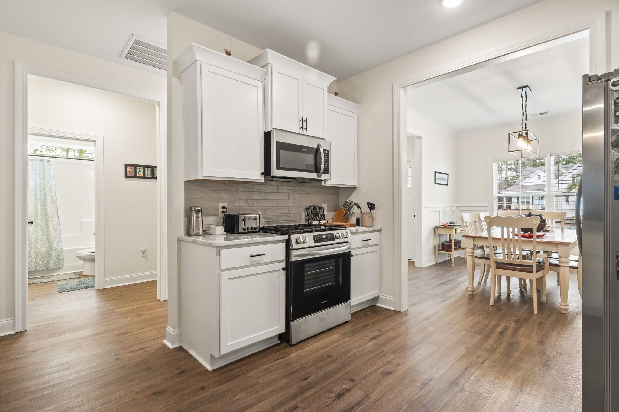 207 Putney Court Conway, SC 29526 - Photo 9 of 38 Kitchen with appliances with stainless steel finishes, white cabinets, healthy amount of natural light, and dark wood-style flooring