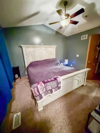 a spacious bedroom with a bed and a chandelier