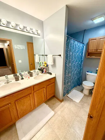 a spacious bathroom with a double vanity sink a mirror and a shower
