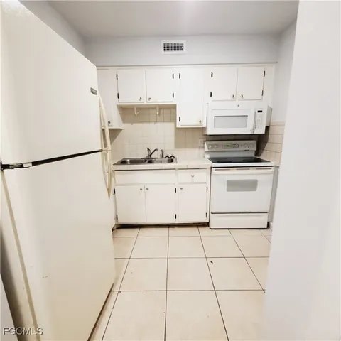 a kitchen with stainless steel appliances a refrigerator sink and cabinets