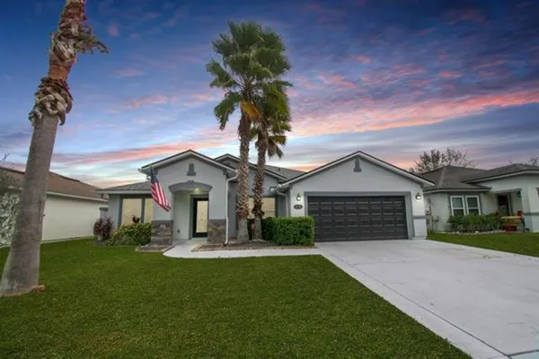 a front view of a house with a garden and plants