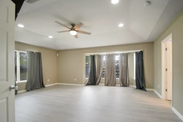 an empty room with closet and windows
