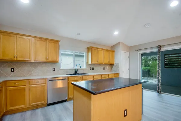 a kitchen with stainless steel appliances granite countertop a sink a stove and a refrigerator