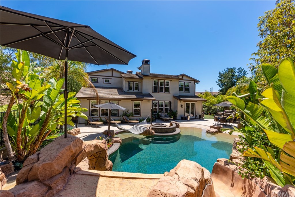 5 Kane Lane Ladera Ranch, CA 92694 - Photo 1 of 1 a view of a swimming pool with lawn chairs under an umbrella
