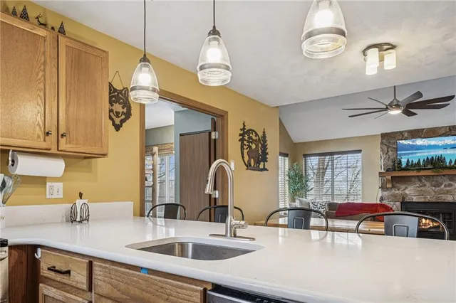 a kitchen with kitchen island granite countertop a sink a counter space appliances and cabinets
