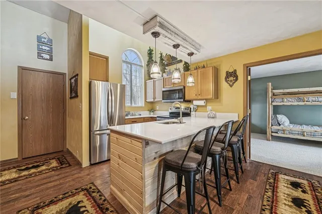 a kitchen with stainless steel appliances kitchen island granite countertop a refrigerator and a stove top oven