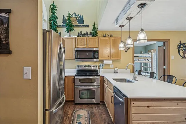 a kitchen that has a sink a stove and a refrigerator