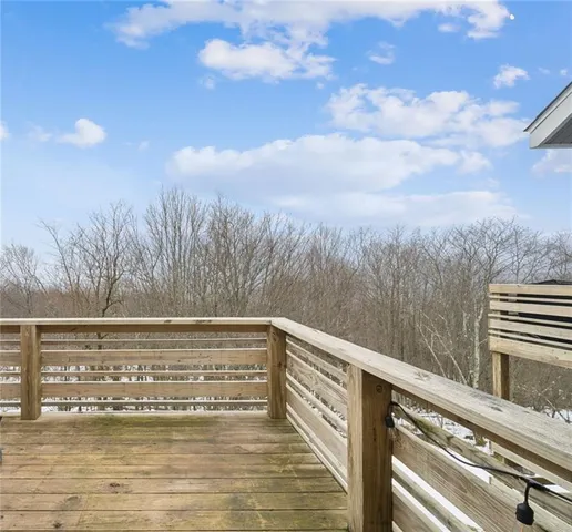 a view of a swimming pool with a bench and trees in the background